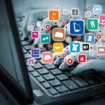 mano su pc portatile e tante icone di business online