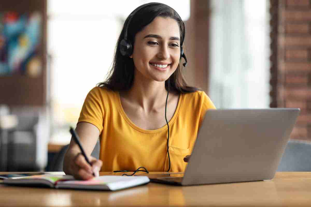 ragazza sorridente davanti al pc frequenta il corso online